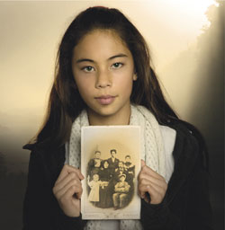 Image of girl holding photo from the cover of the Heritage Festival 2008 programme. 