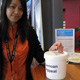 Woman putting money into donation bucket.
